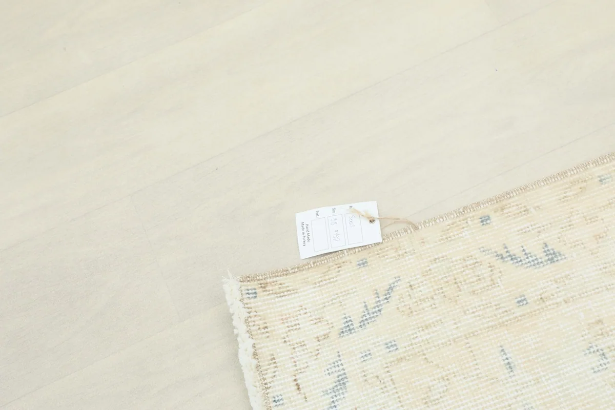 A small tag attached to the corner of the rug, indicating its unique identification.