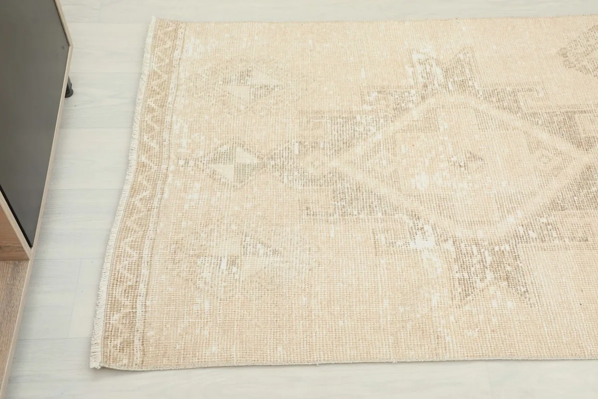 Detailed view of the subtle border design and the soft patina on the runner rug
