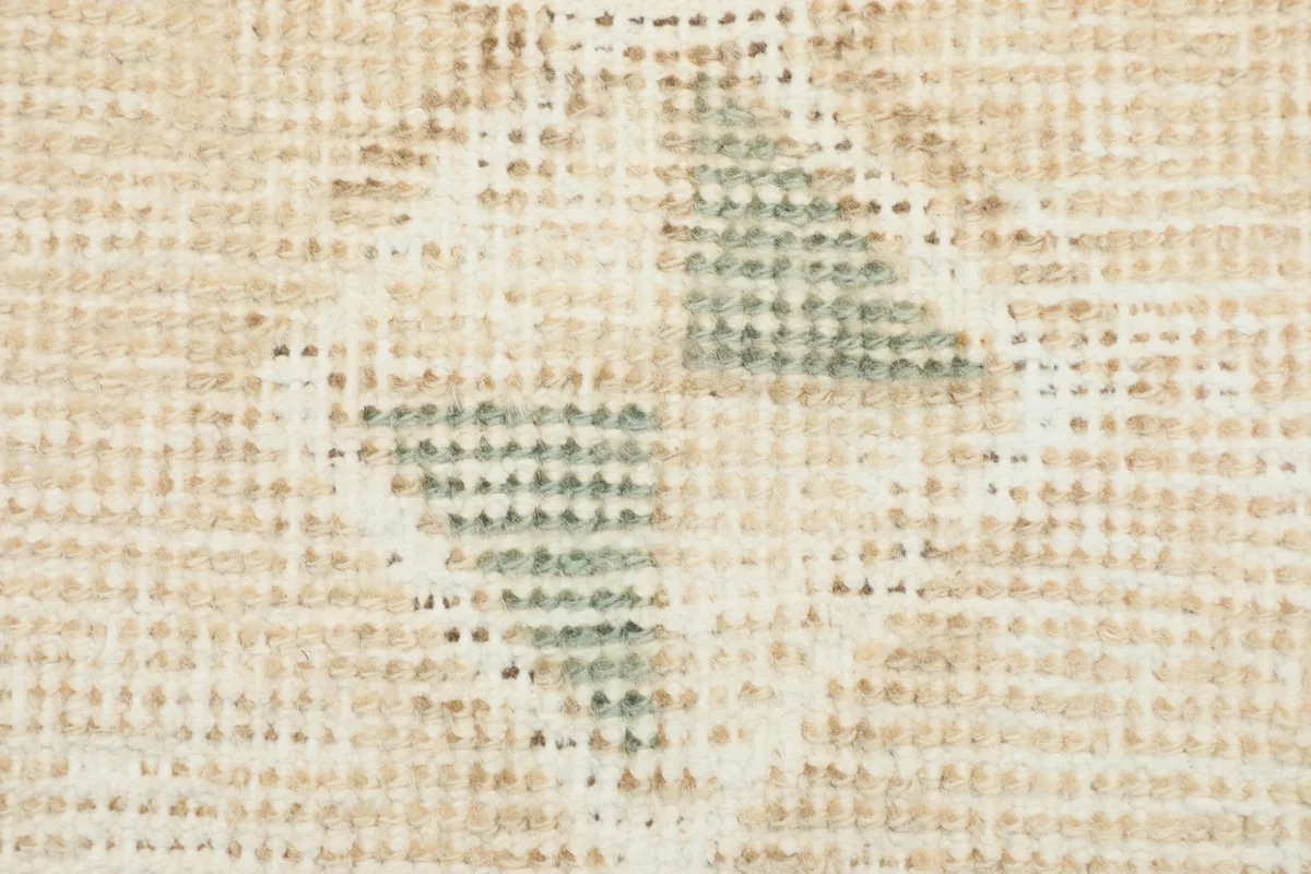 Extreme close-up showing the low wool pile and hand-knotted texture of the rug