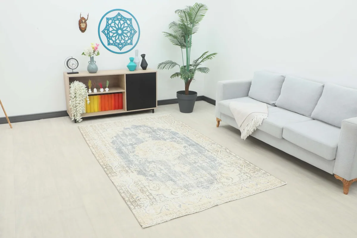 Vintage gray and ivory rug placed in a modern living room setting with a light gray sofa.