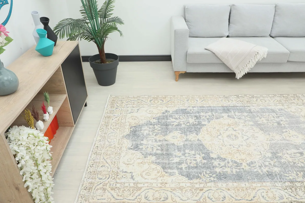 Angle view of the rug in a room, highlighting its size relative to a sofa and cabinet.
