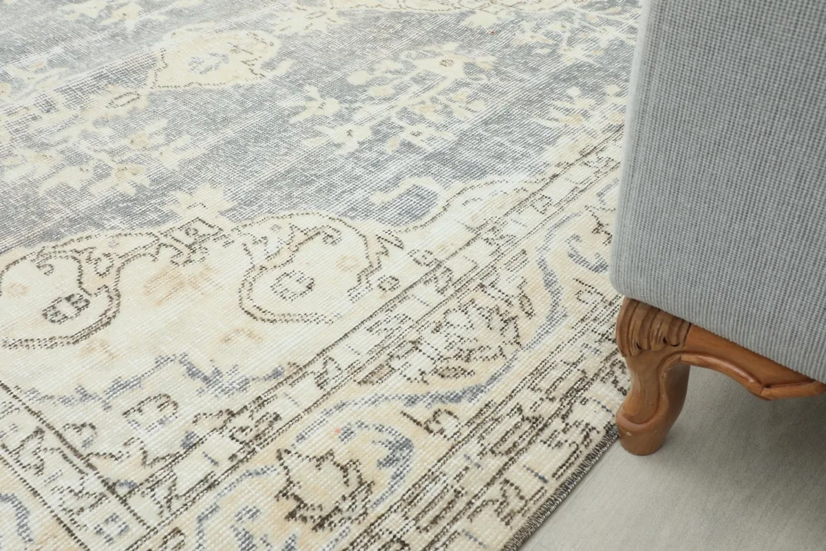 Rug positioned next to a gray sofa, showing how it complements contemporary furniture.