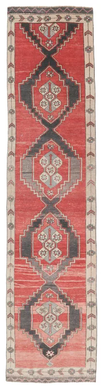 Full overhead view of the red and charcoal geometric Anatolian runner on a white background