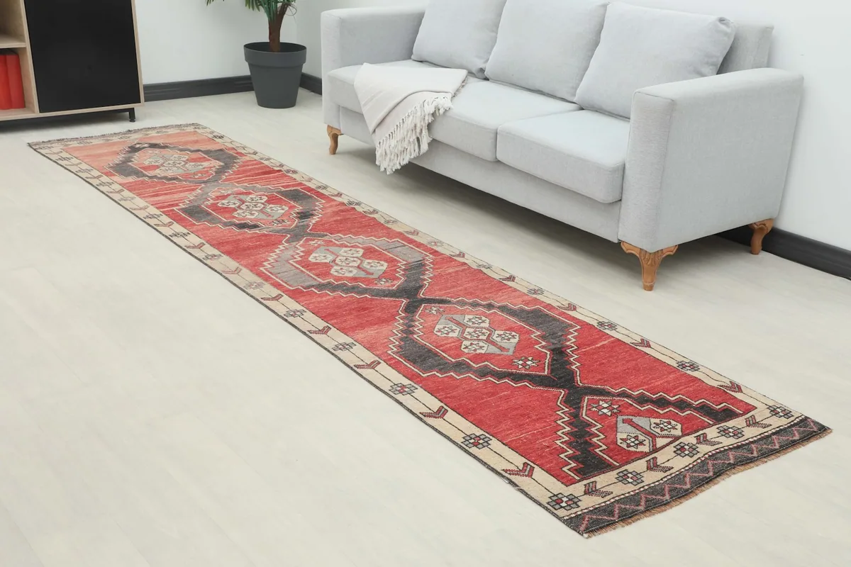 Angled view of the red and charcoal runner rug extending through a hallway space