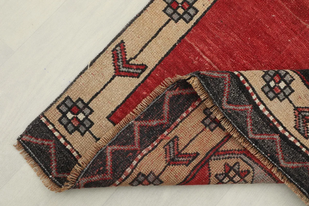 Corner of the rug folded to show the hand-knotted wool pile and cotton foundation