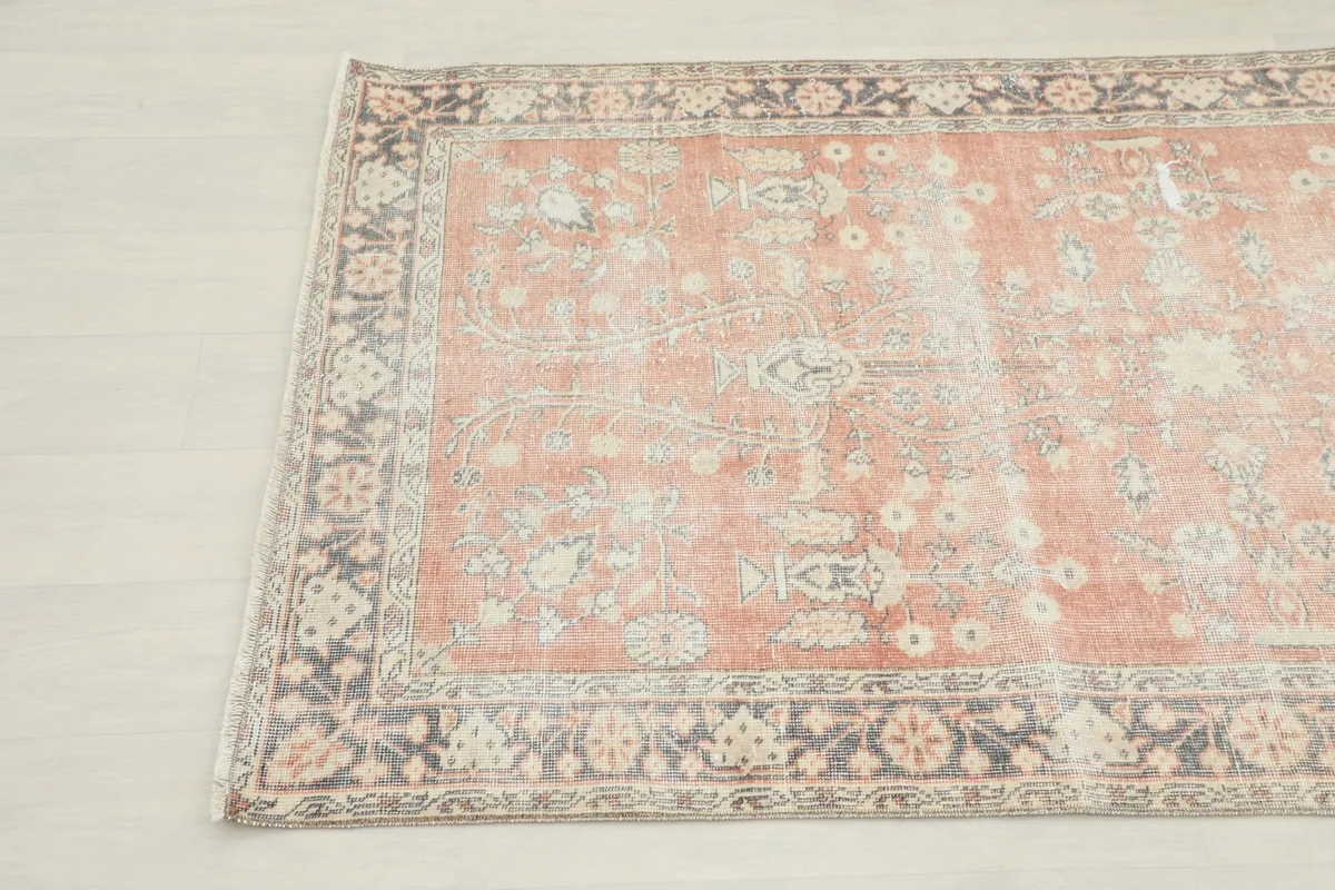 Close-up angle of the vintage rose rug's floral and geometric motifs