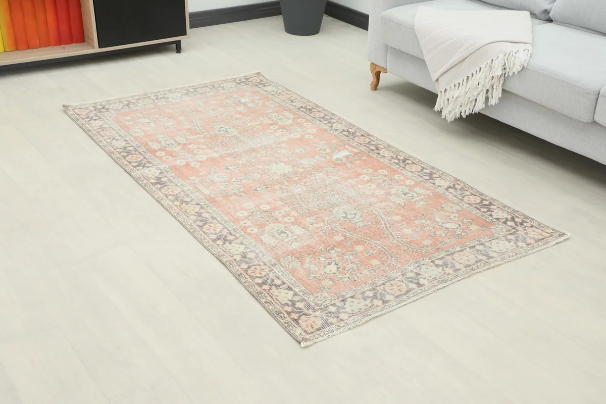 Angle view of the rose and gray vintage Anatolian rug in a room