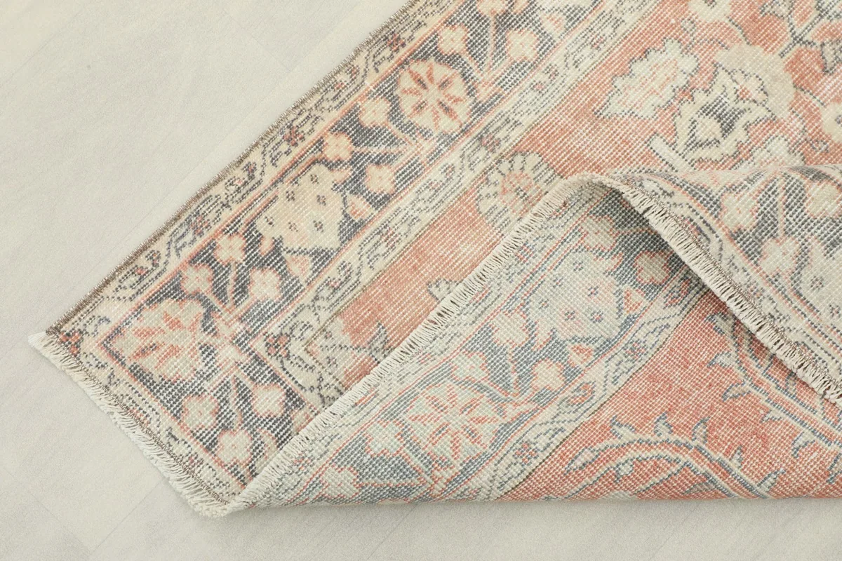Corner of the vintage Anatolian rug folded back to show the cotton foundation
