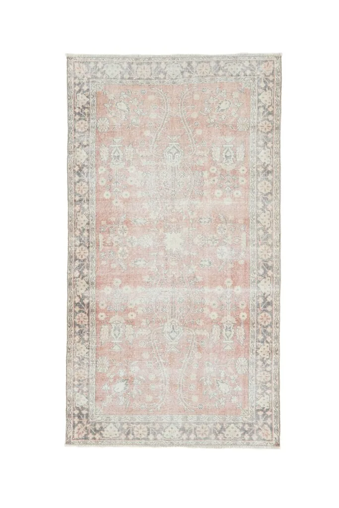 Overhead view of the rose and gray vintage Anatolian rug on a white background