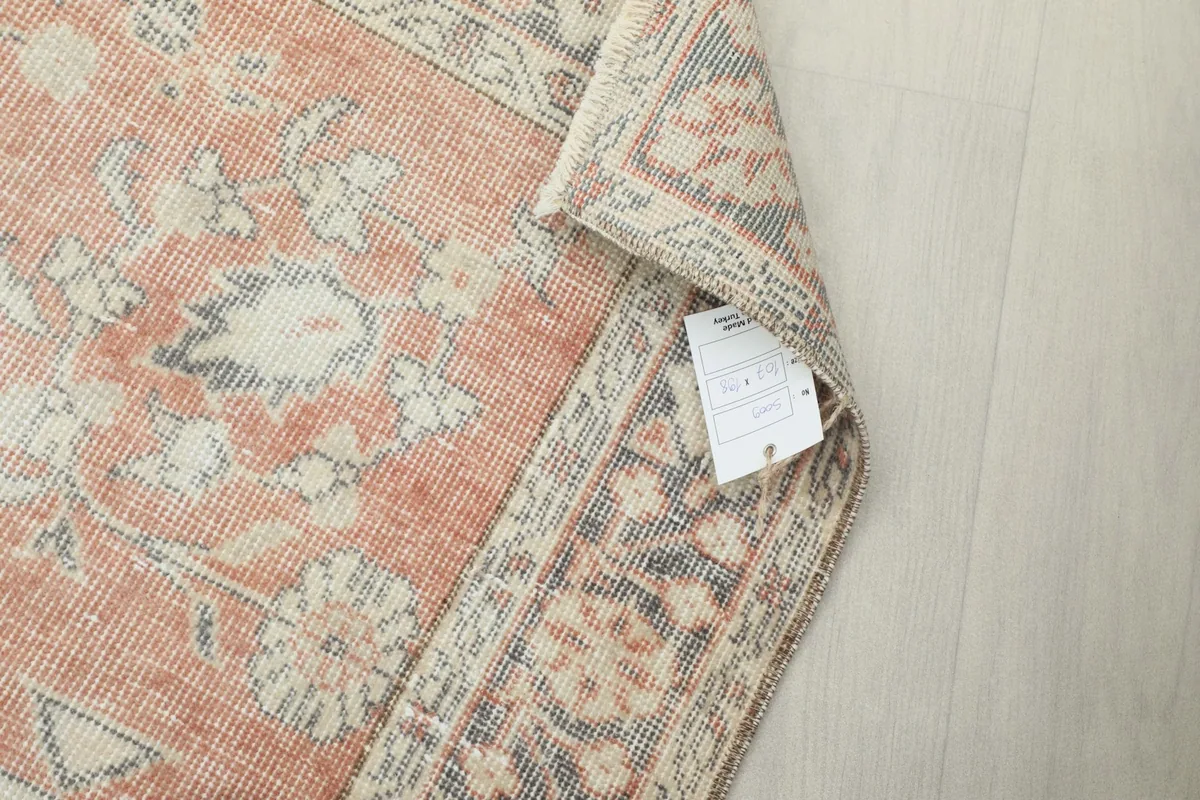 Rug corner with a label, showing the back of the hand-knotted construction