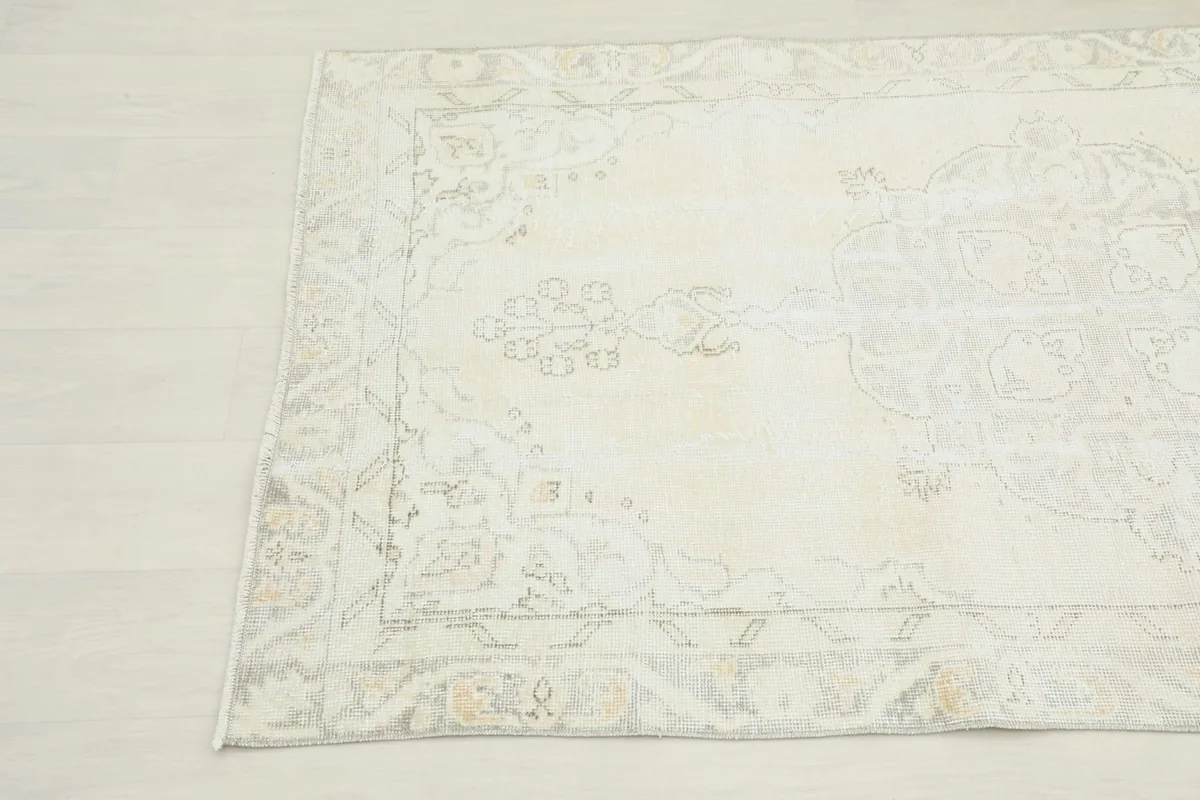 Detailed corner view of the rug, highlighting its soft ivory and gray color palette