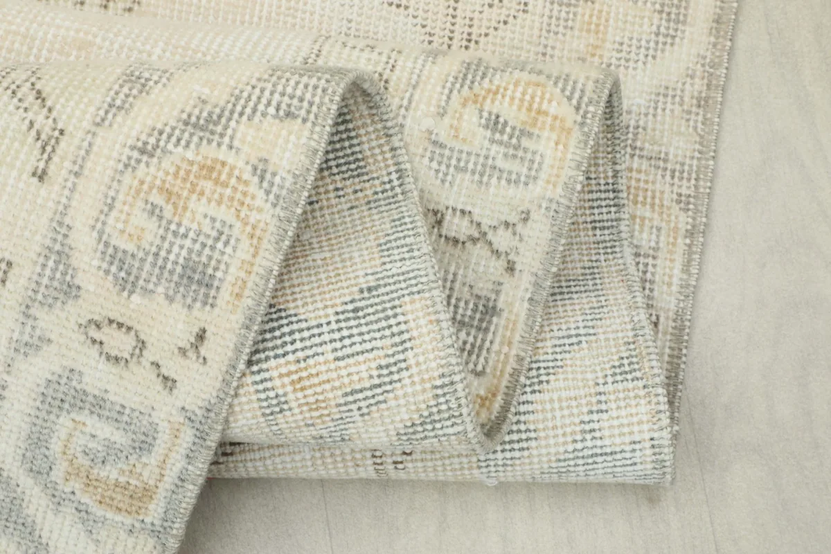 Close-up of the rug folded, showing the density of the knots and faded colors
