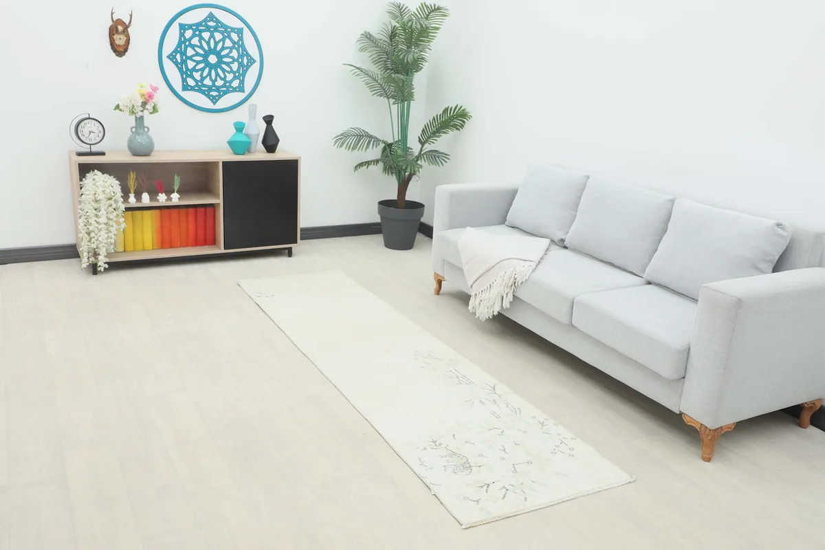 Ivory runner rug placed in a modern living room setting with a light gray sofa