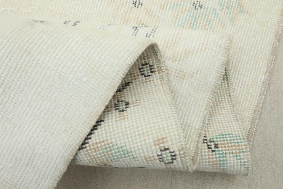 Multiple folds of the rug showing the reverse side of the hand-knotted cotton foundation