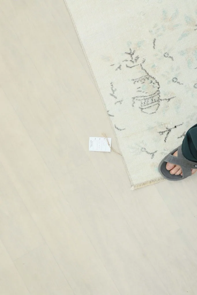 Overhead view of a person's foot next to the rug, indicating scale