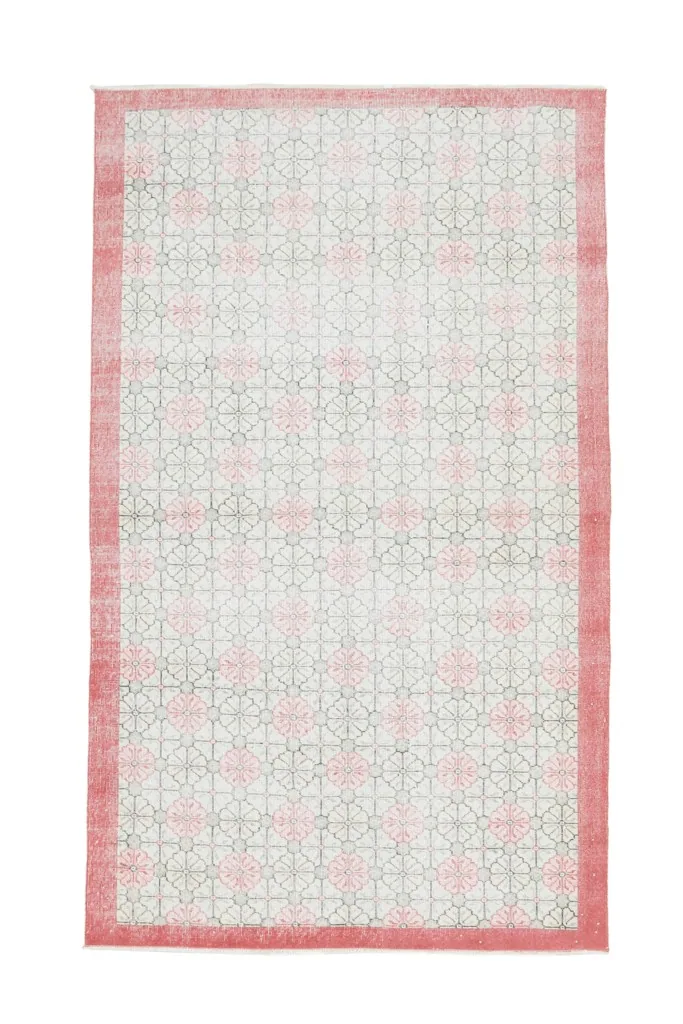 Full overhead shot of the vintage pink and ivory Anatolian rug on a white background.