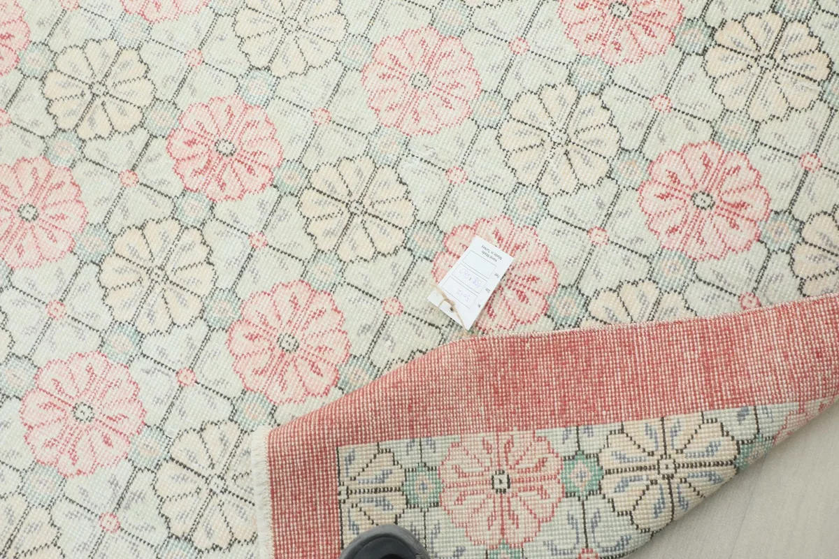 View of the rug with a tag, showing the quality and detailing of the hand-knotted craftsmanship.