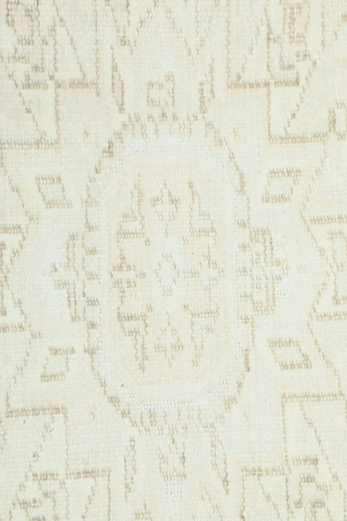 Close-up of the intricate, faded geometric design within the rug's field.