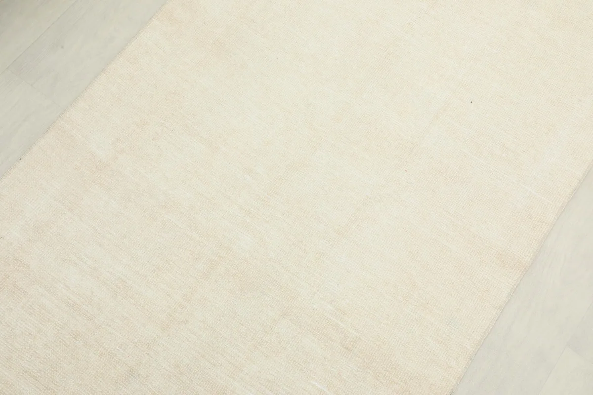 Angled view of the middle section of the ivory and beige runner, showing its soft color