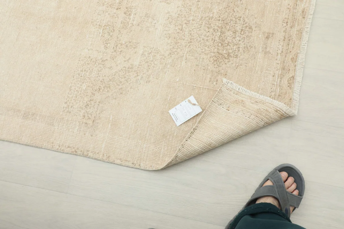 Close-up of the rug's surface with a small tag, showing the soft texture and subtle pattern