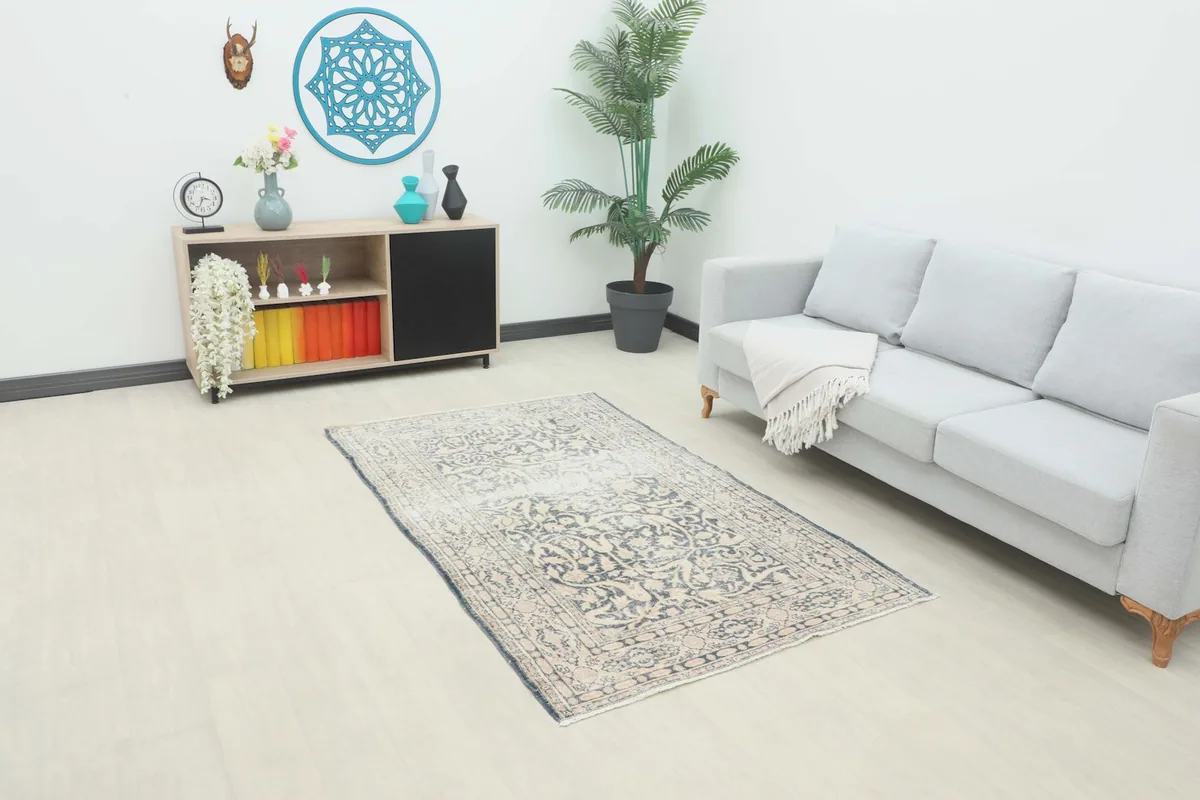 Gray and beige rug in a modern living room setting with a light gray sofa and wooden cabinet