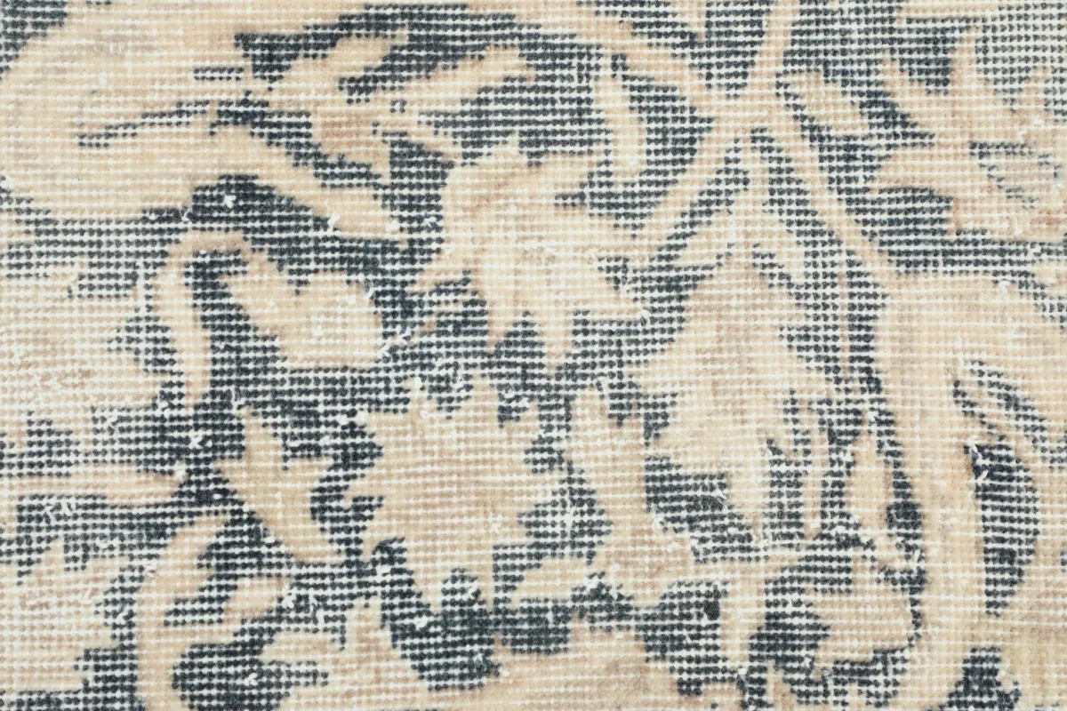 Detailed close-up of the hand-knotted wool pile, showing the texture and faded colors