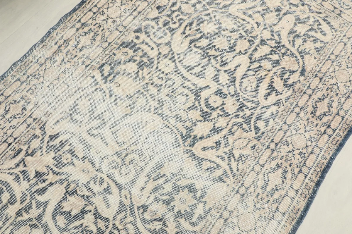 Overhead view of the rug's center, revealing the distinct floral motifs and areas of lighter patina