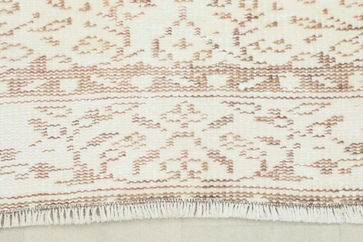 Close-up view of the rug's short fringe and a section of the border pattern