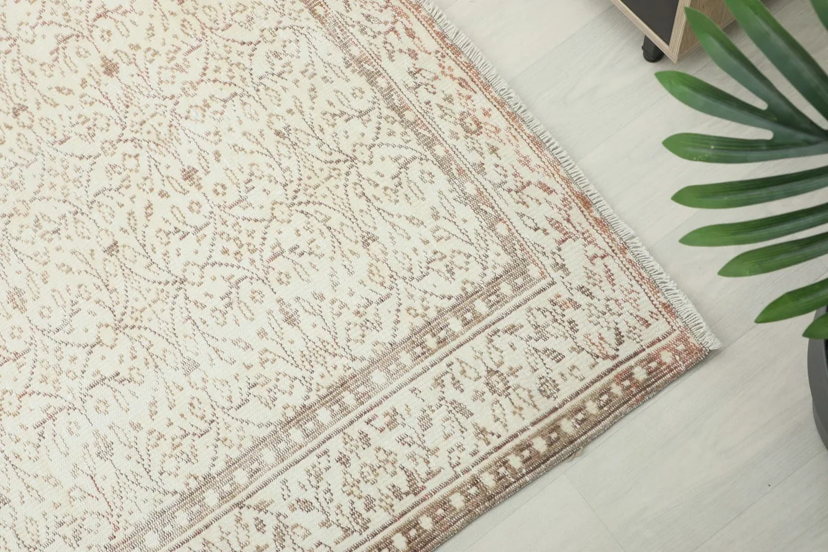 Corner detail of the rug, highlighting the tan border design and cream field
