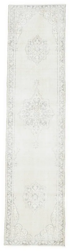 Full overhead view of the vintage ivory and gray Anatolian runner rug on a white background