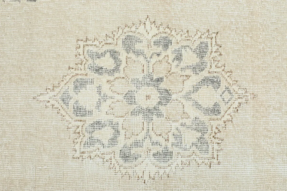 Very close view of the intricate floral and geometric details within a medallion on the rug