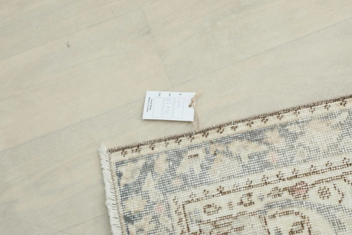 Small tag attached to the rug's edge, indicating its origin and material on a light floor