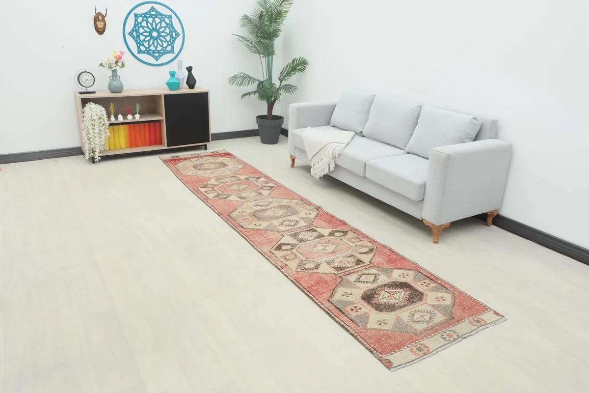 Vintage Anatolian runner rug displayed in a modern room setting with a sofa