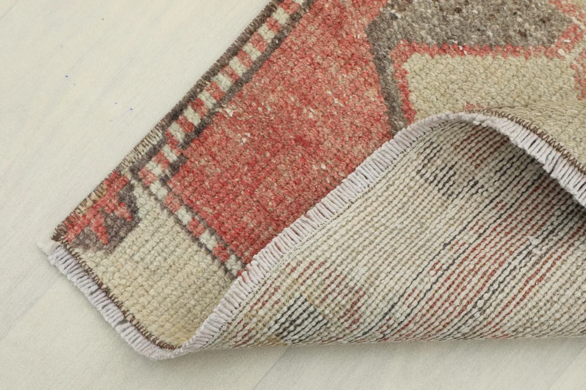 Corner of the rug folded to show the cotton foundation and hand-knotted construction