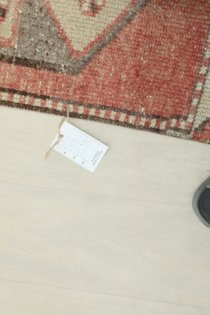 Overhead view of a small tag on the floor next to the runner rug
