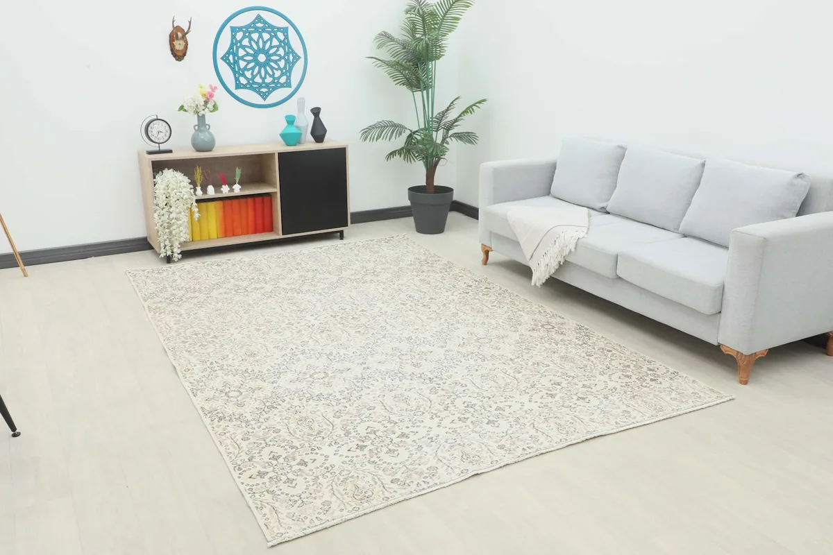 Ivory vintage rug placed in a modern living room setting with a light gray sofa