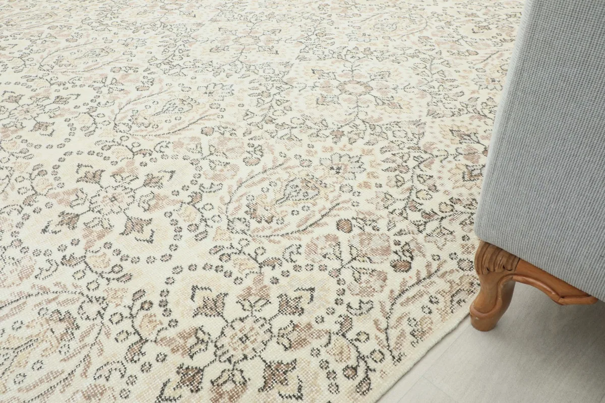 Detail shot of the rug's pattern near the edge, next to the leg of a piece of furniture