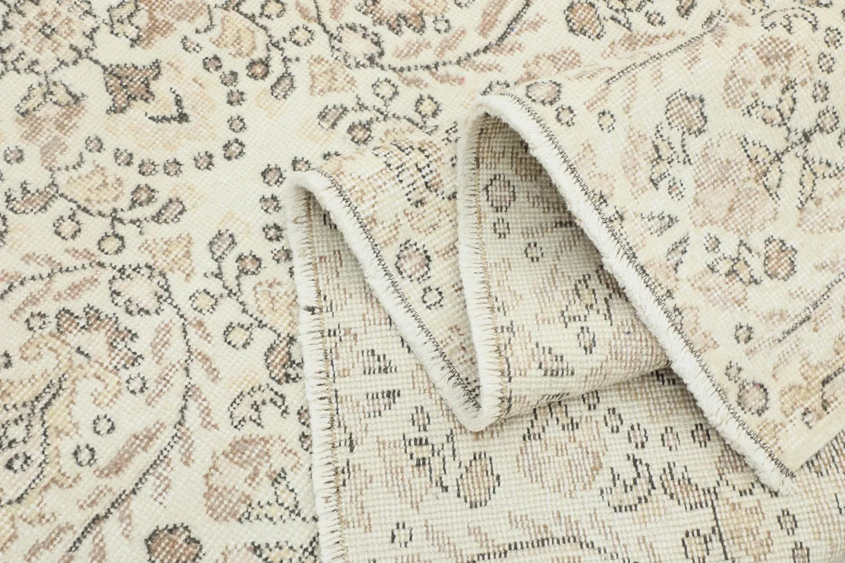 Close-up of the rug's low wool pile and the texture of the vintage hand-knotted weave