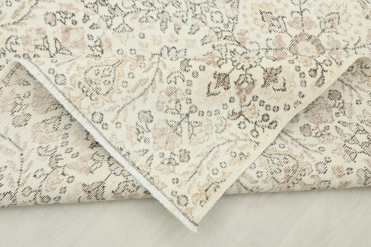Corner of the rug folded back, revealing the reverse side of the hand-knotted construction