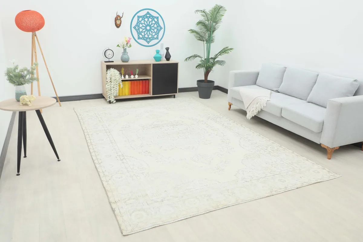 Ivory vintage rug placed in a modern living room setting with a light gray sofa