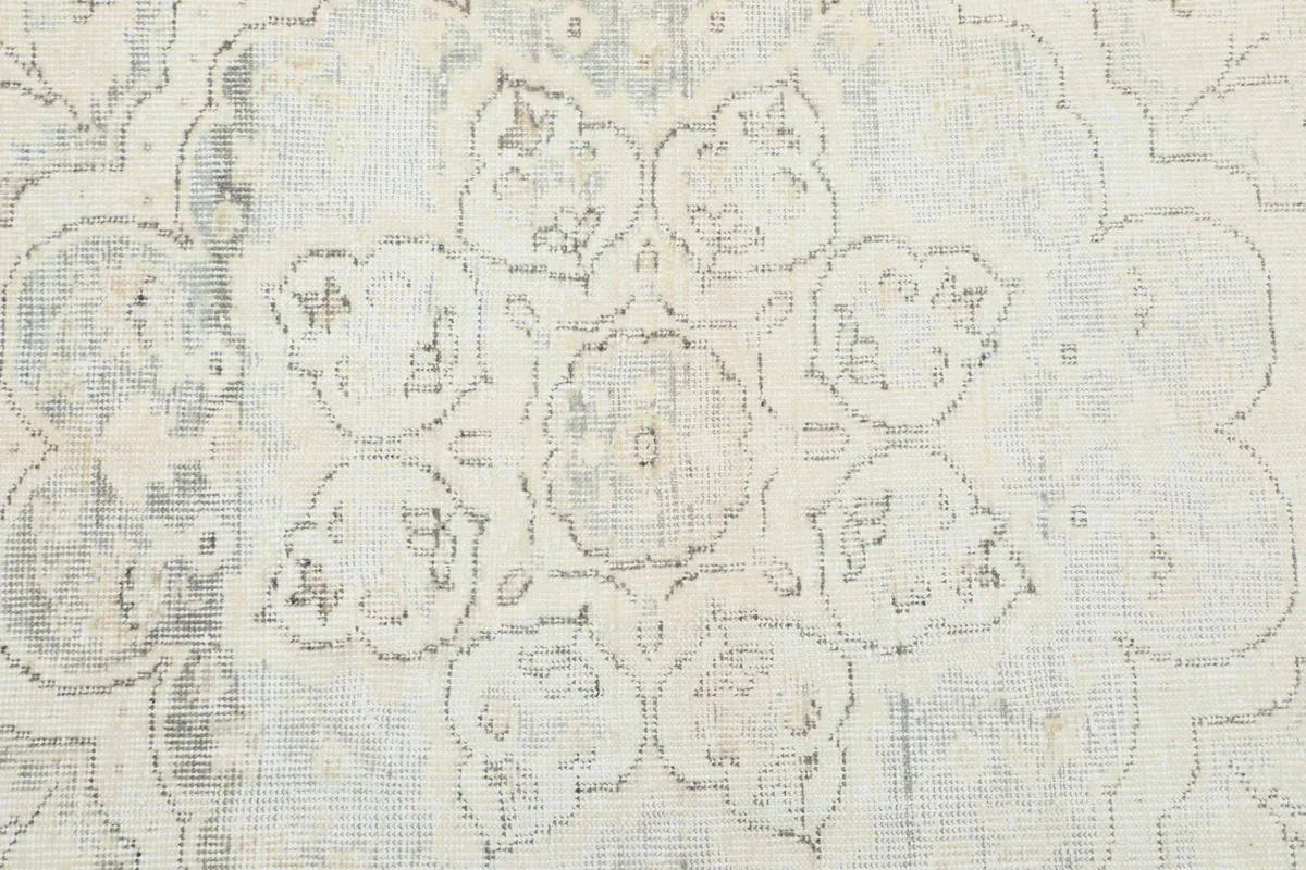Close-up showing the subtle blue and gray tones within the rug's floral patterns