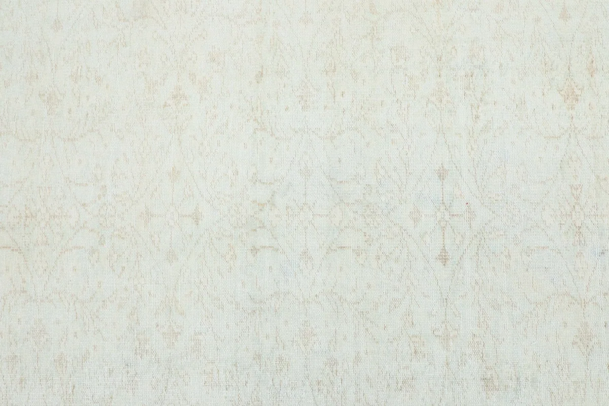 Full overhead view of the cream rug, highlighting the subtle, faded floral and geometric patterns.