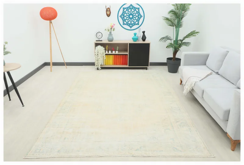 Full top view of the 6'9" x 9'9" ivory and blue vintage Anatolian area rug on a white background.
