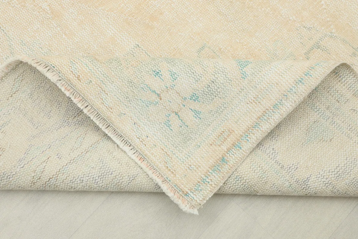View of the underside of the rug, showing the cotton foundation and hand-knotted construction.