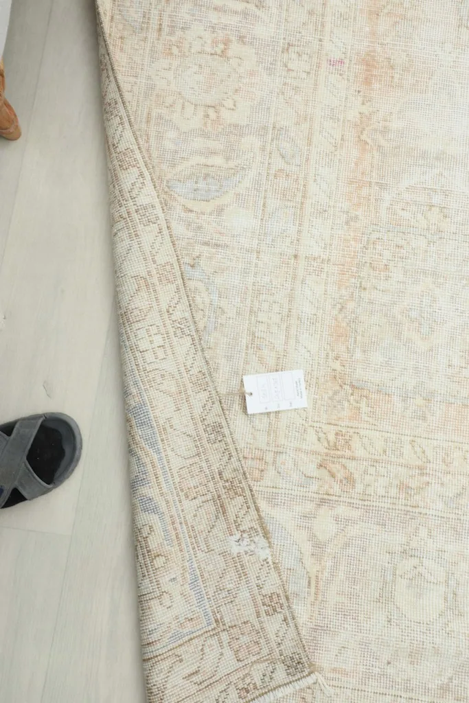A person's foot next to the rug, showing its thickness and the texture of the low pile.