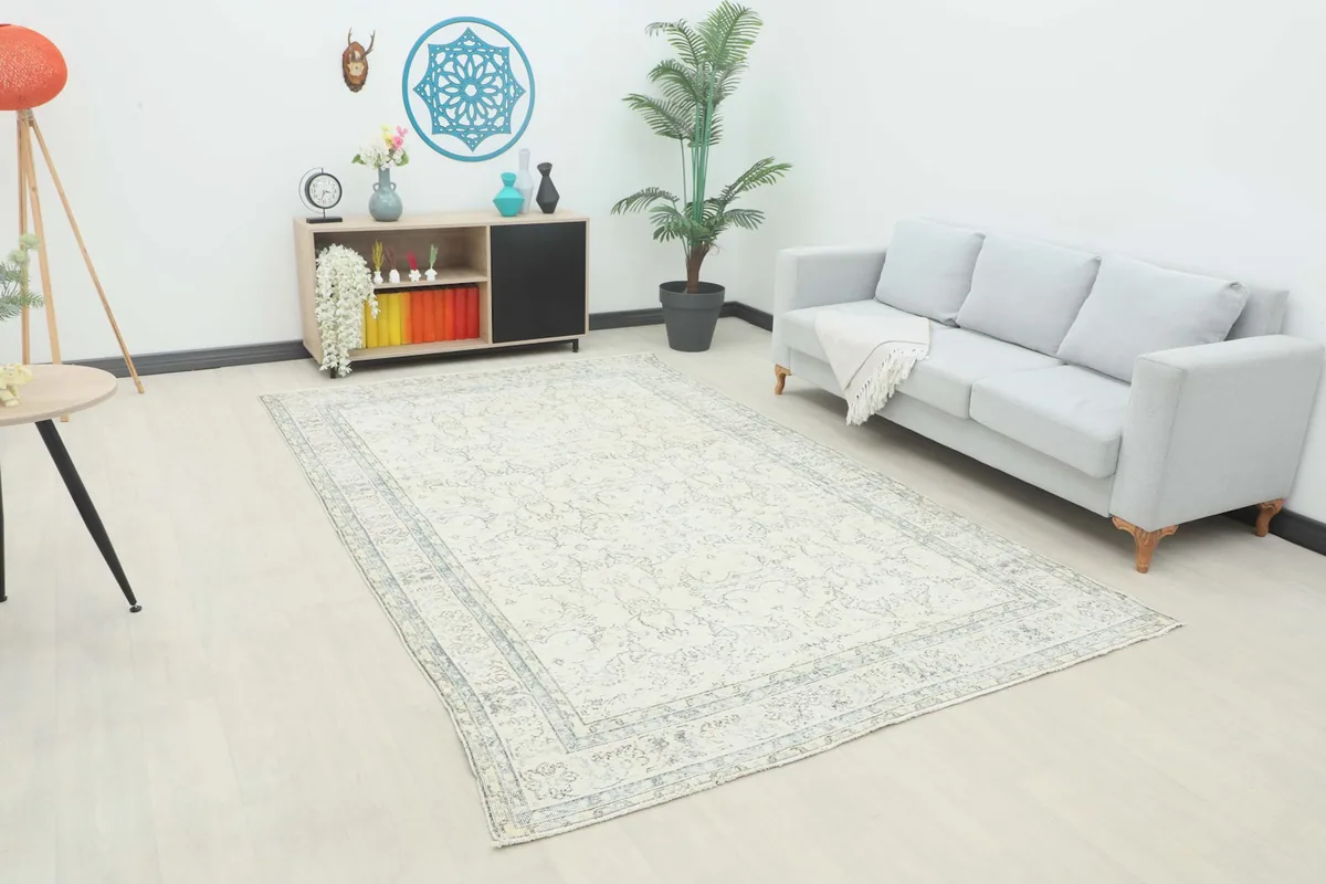Ivory and gray floral medallion area rug displayed in a living room setting