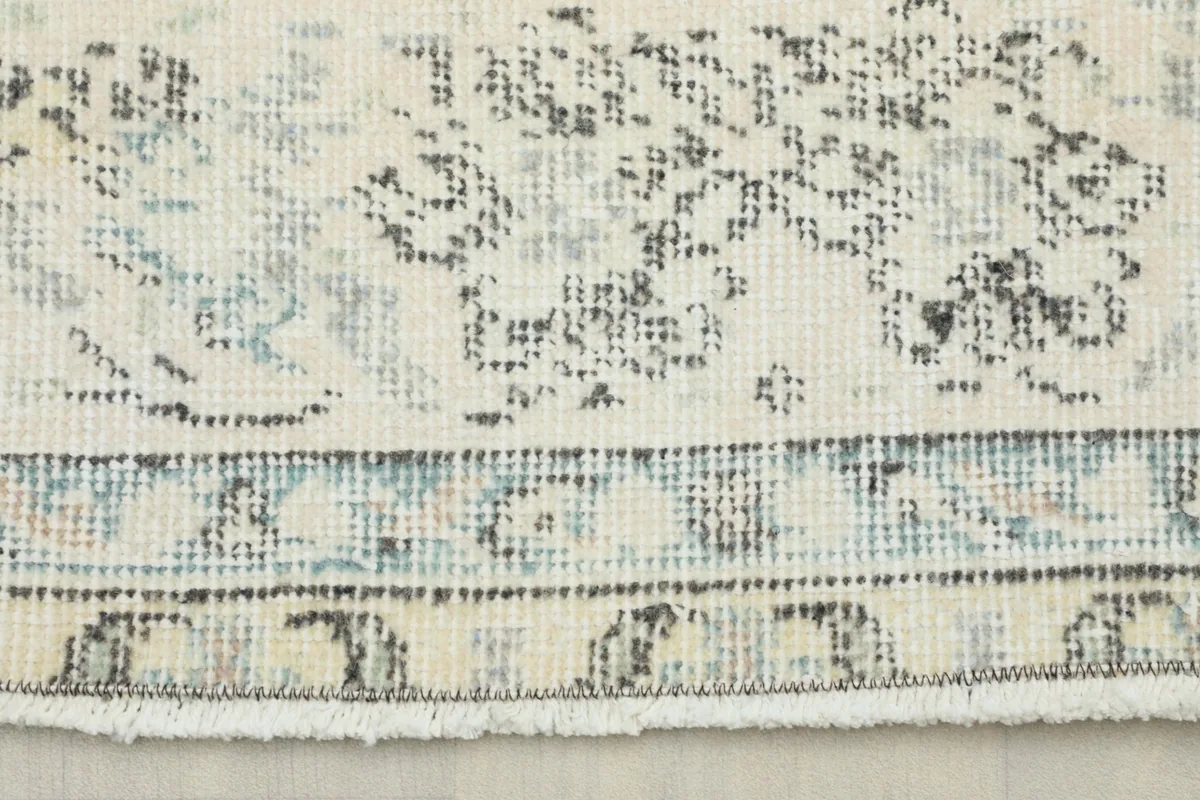 Close-up detail of the rug's border and fringe, showing colors and texture