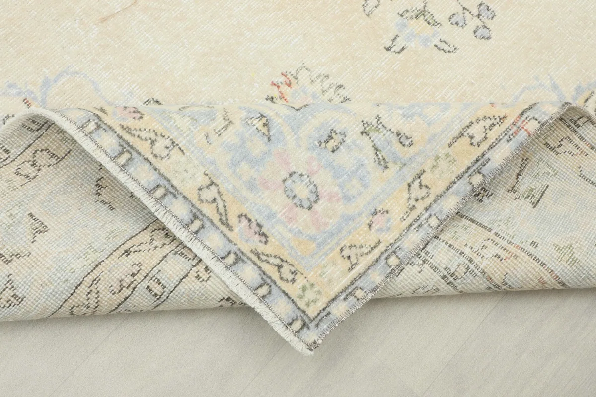 Folded corner of the rug showing the reverse side and the hand-knotted cotton foundation.