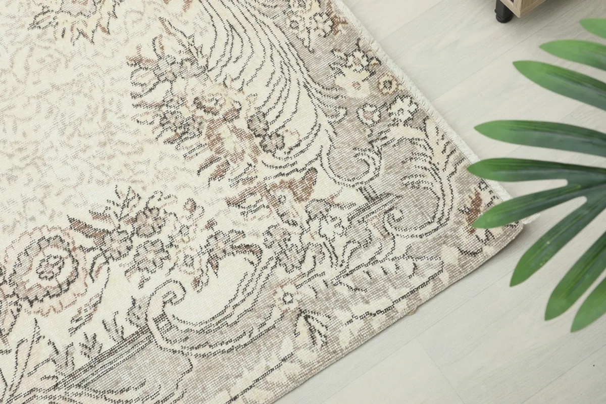 Close-up of the rug's corner and border design, highlighting the muted colors and patterns
