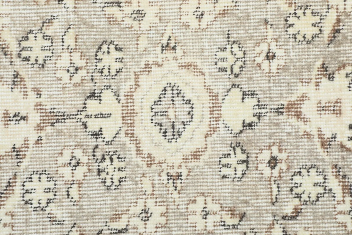 Detailed view of the low pile texture and intricate knotting of the rug's central design